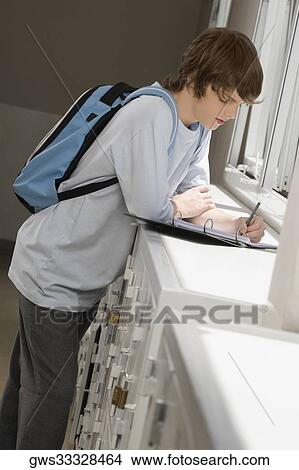 Side profile of a high school student writing in a ring binder View Large Photo Image Picture - Side profile of a high school student writing in a ring binder. Fotosearch