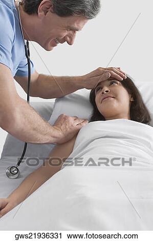 Stock Image - Side profile of a male doctor consoling a female patient. Fotosearch
