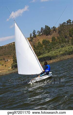 Stock Image - Side profile of a person participating in a sailboat race. Fotosearch