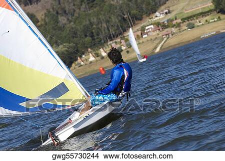 Side profile of a person sitting in a sailboat View Large Photo Image Picture - Side profile of a person sitting in a sailboat. Fotosearch