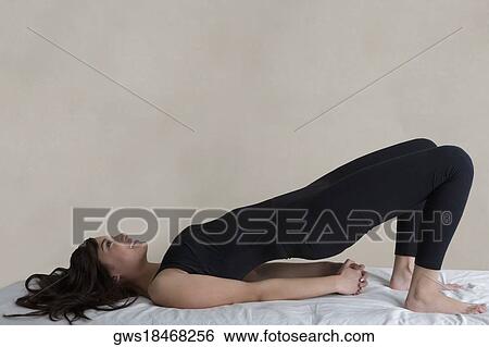 Side profile of a young woman practicing yoga and smiling View Large Photo Image Stock Photograph - Side profile of a young woman practicing yoga and smiling. Fotosearch