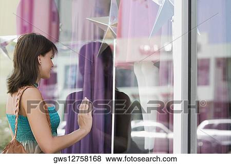 Stock Photo - Side profile of a young woman window shopping. Fotosearch