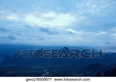 Stock Image - Silhouette of hill ranges at dusk, Guilin Hills, Xingping, Yangshuo, Guangxi Province, China. Fotosearch