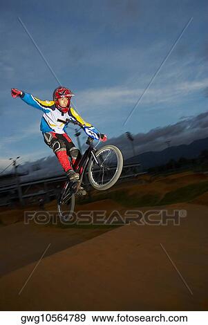 Teenage boy performing a stunt on a bicycle View Large Photo Image Stock Photo - Teenage boy performing a stunt on a bicycle. Fotosearch