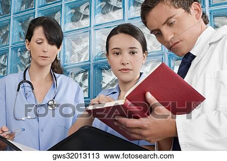 Three doctors discussing on medical records View Large Photo Image Stock Image - Three doctors discussing on medical records. Fotosearch