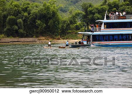 Stock Image - Tour boat in a river, XingPing, Yangshuo, Guangxi Province, China. Fotosearch