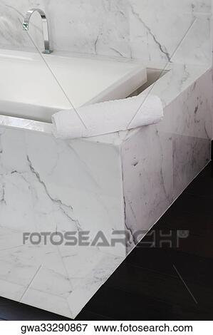 Stock Photo - Towel on the ledge of a bathtub. Fotosearch