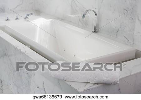 Stock Photo - Towel on the ledge of a bathtub. Fotosearch