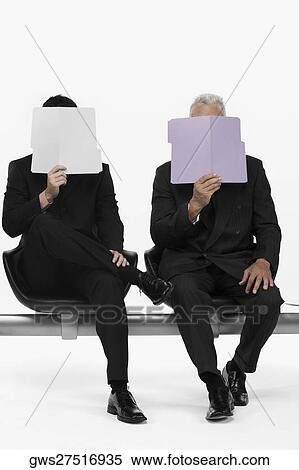 Two businessmen holding files in front of their faces View Large Photo Image Stock Photography - Two businessmen holding files in front of their faces. Fotosearch