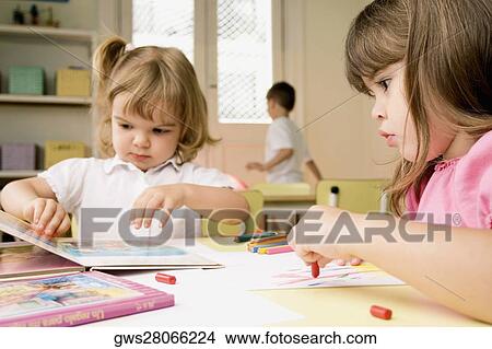 Two girls drawing on sheets of paper View Large Photo Image Picture - Two girls drawing on sheets of paper. Fotosearch