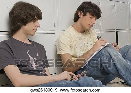 Stock Photo - Two high school students studying in front of lockers. Fotosearch