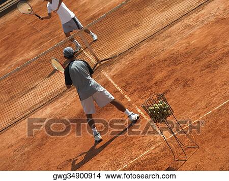 Picture - Two male tennis players playing tennis. Fotosearch