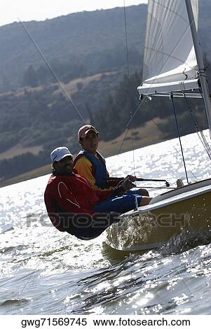 Stock Photography - Two men participating in a sailboat race. Fotosearch