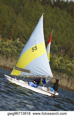 Two people participating in a sailboat race View Large Photo Image Stock Photo - Two people participating in a sailboat race. Fotosearch