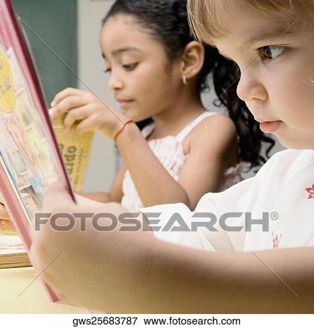 Two students reading in a classroom View Large Photo Image Stock Photo - Two students reading in a classroom. Fotosearch