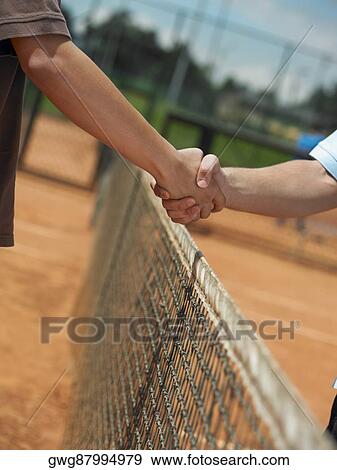 Two tennis players shaking hands over a net View Large Photo Image Stock Photo - Two tennis players shaking hands over a net. Fotosearch