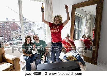 Two young couples watching television and drinking beer in a living room View Large Photo Image Stock Image - Two young couples watching television and drinking beer in a living room. Fotosearch