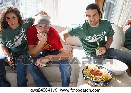 Stock Image - Two young men and a young woman drinking beer. Fotosearch