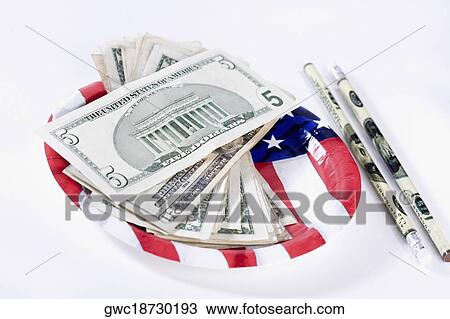 Stock Image - US dollar bills with an American flag and pencils. Fotosearch