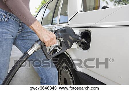 Woman refueling a car at a gas station View Large Photo Image Stock Image - Woman refueling a car at a gas station. Fotosearch