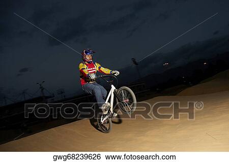 Young man performing a stunt on a bicycle View Large Photo Image Stock Photograph - Young man performing a stunt on a bicycle. Fotosearch