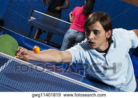 Young man playing table tennis View Large Photo Image Stock Photo - Young man playing table tennis. Fotosearch