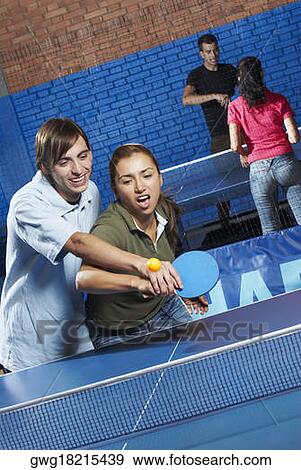 Young man teaching table tennis to a young woman View Large Photo Image Stock Photo - Young man teaching table tennis to a young woman. Fotosearch
