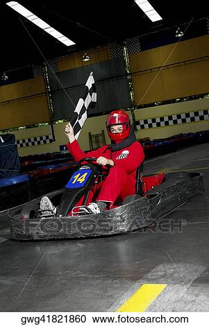 Stock Image - Young woman go-carting on a motor racing track. Fotosearch