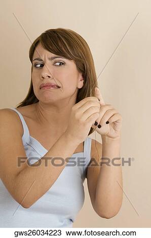 Young woman pinching her finger with a needle View Large Photo Image Stock Image - Young woman pinching her finger with a needle. Fotosearch
