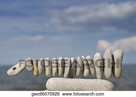 Balancing rocks in a row on the beach View Large Photo Image Stock Photograph - Balancing rocks in a row on the beach. Fotosearch