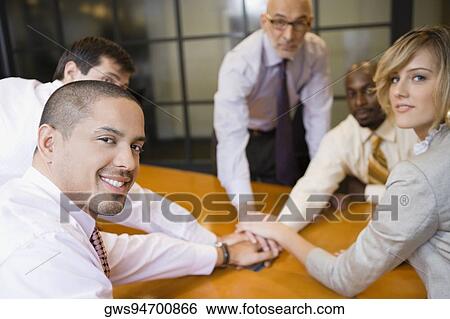 Business executives placing their hands on each other View Large Photo Image Stock Photograph - Business executives placing their hands on each other. Fotosearch