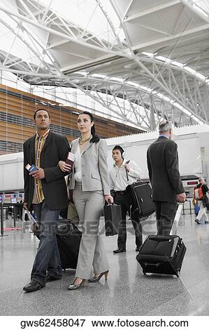 Business executives walking at an airport View Large Photo Image Stock Photo - Business executives walking at an airport. Fotosearch