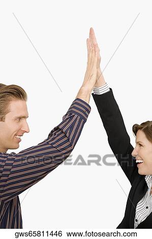 Businessman and a businesswoman giving high-five and smiling View Large Photo Image Stock Photograph - Businessman and a businesswoman giving high-five and smiling. Fotosearch