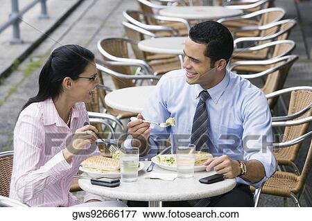 Businessman and a businesswoman having lunch at a sidewalk cafe View Large Photo Image Stock Photo - Businessman and a businesswoman having lunch at a sidewalk cafe. Fotosearch