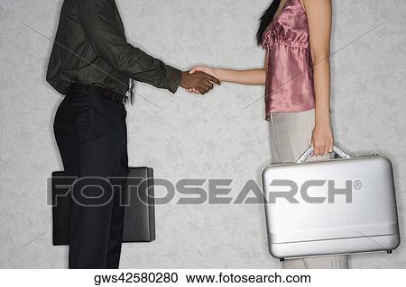 Businessman and a businesswoman shaking hands View Large Photo Image Stock Image - Businessman and a businesswoman shaking hands. Fotosearch