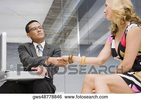 Businessman and a businesswoman shaking hands View Large Photo Image Stock Photograph - Businessman and a businesswoman shaking hands. Fotosearch