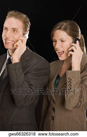 Businessman and a businesswoman talking on mobile phones View Large Photo Image Stock Photo - Businessman and a businesswoman talking on mobile phones. Fotosearch