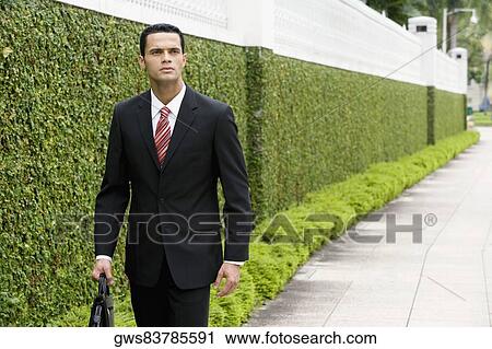 Businessman carrying a briefcase View Large Photo Image Stock Image - Businessman carrying a briefcase. Fotosearch