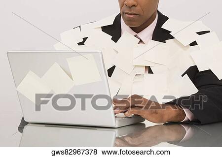 Businessman covered with adhesive notes and working on a laptop View Large Photo Image Stock Photo - Businessman covered with adhesive notes and working on a laptop. Fotosearch