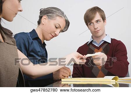 Businessman giving a paper to a businesswoman View Large Photo Image Stock Image - Businessman giving a paper to a businesswoman. Fotosearch