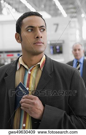 Stock Photo - Businessman putting a passport in his pocket. Fotosearch