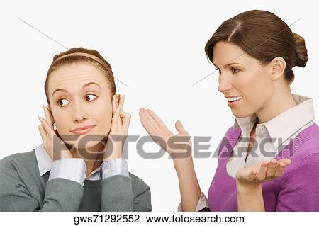 Businesswoman gesturing with her colleague ignoring her View Large Photo Image Stock Image - Businesswoman gesturing with her colleague ignoring her. Fotosearch