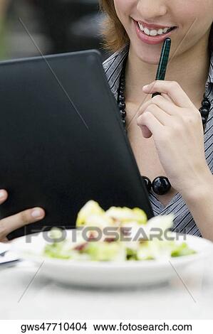 Businesswoman holding a ring binder at a sidewalk cafe View Large Photo Image Picture - Businesswoman holding a ring binder at a sidewalk cafe. Fotosearch