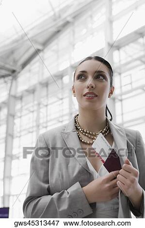Businesswoman putting a passport with an airplane ticket in her coat's pocket View Large Photo Image Stock Photo - Businesswoman putting a passport with an airplane ticket in her coat's pocket. Fotosearch