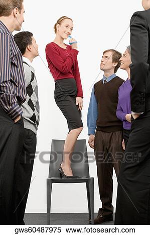 Businesswoman standing on a chair and blowing whistle with business executives standing beside her View Large Photo Image Stock Photography - Businesswoman standing on a chair and blowing whistle with business executives standing beside her. Fotosearch