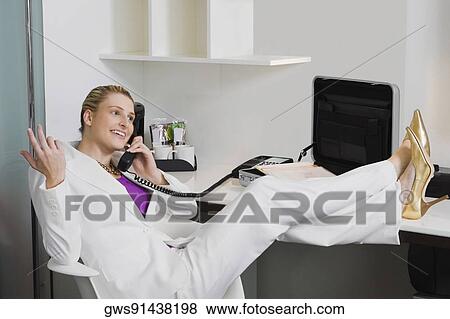 Businesswoman talking on the phone and smiling View Large Photo Image Stock Photo - Businesswoman talking on the phone and smiling. Fotosearch