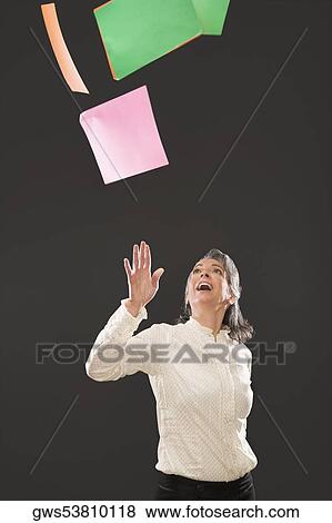 Businesswoman throwing papers in the air View Large Photo Image Stock Photo - Businesswoman throwing papers in the air. Fotosearch