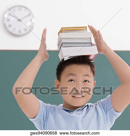 Close-up of a boy balancing books on his head View Large Photo Image Stock Photo - Close-up of a boy balancing books on his head. Fotosearch