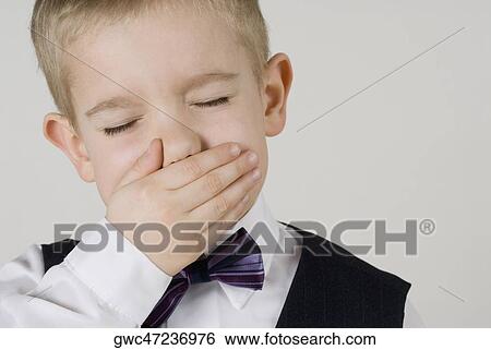 Close-up of a boy covering his mouth with his hands View Large Photo Image Stock Photograph - Close-up of a boy covering his mouth with his hands. Fotosearch