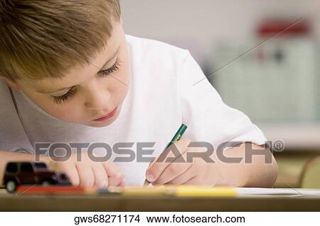 Close-up of a boy drawing on a sheet of paper View Large Photo Image Picture - Close-up of a boy drawing on a sheet of paper. Fotosearch